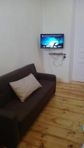a couch in a living room with a flat screen tv at Sololaki Dadiani in Tbilisi City