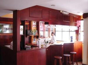 a man standing at a bar in a restaurant at Hotel Real Park in Jacareí