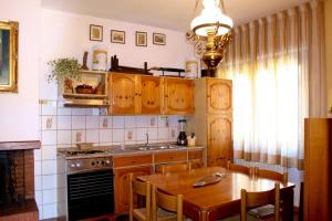 a kitchen with wooden cabinets and a wooden table with a dining room at Morianese Residence in Lucca +54 photos