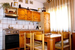 a kitchen with wooden cabinets and a table with chairs at Morianese Residence in Lucca