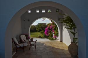 an archway leading to a patio with flowers at Ammos Naxos Exclusive Apartments & Studios in Naxos Chora