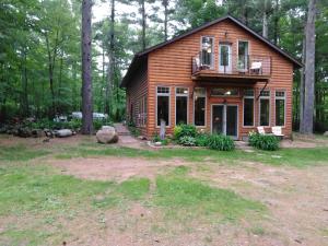 a log cabin in the woods with a balcony at Bed and breakfast suite at the Wooded Retreat in Pine City