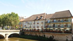 a building next to a river with a bridge at Best Western Le Pont d'Or in Figeac
