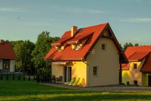 ein Haus mit einem orangenen Dach mit einem Tisch davor in der Unterkunft Mazurski domek in Mrągowo