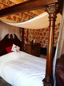Inverbervie的住宿－Hallgreen castle，一间卧室配有一张带天蓬和桌子的床