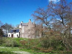 an old stone house on a grassy field at Hallgreen castle in Inverbervie