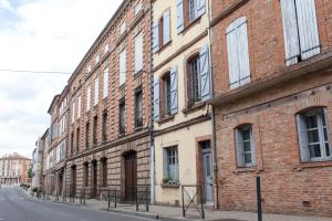 モントーバンにある46FM : Montauban Guest Houseの通路脇のレンガ造りの建物