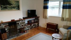 a living room with a fireplace and a tv at Sunways in Padstow