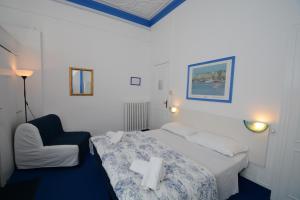 a hotel room with a bed and a chair at Olympia Hotel in Genoa