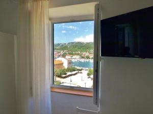 a window with a view of a city and water at Rooms and Studio Old Town in Rab