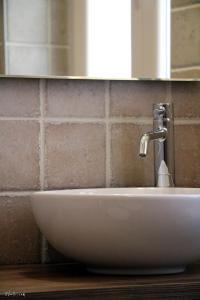 lavabo blanco en el baño con espejo en B&B U Campanin, en Dolceacqua