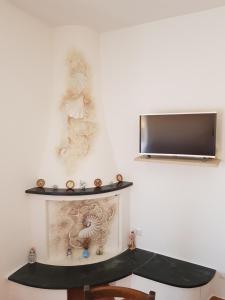 een kamer met een plank en een tv aan de muur bij Appartamento Monte Mare Arzachena in Arzachena