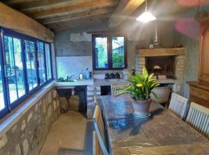 a kitchen with a table and chairs and windows at Mas Ribou in Barbentane