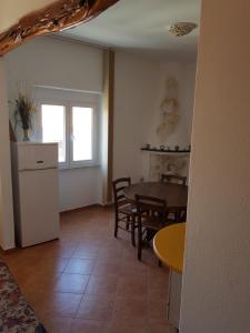 una cucina e una sala da pranzo con tavolo e sedie di Appartamento Monte Mare Arzachena a Arzachena