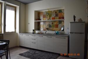  La cuisine est équipée de placards blancs et d'un réfrigérateur. dans l'établissement Appartamento in centro, à Cassino