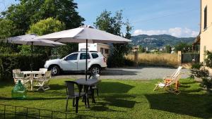una mesa con sombrilla y sillas y un coche en Buio Pesto B&B, en Ceparana