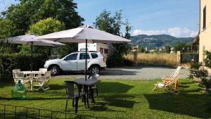 a table with an umbrella and chairs and a car at Buio Pesto in Ceparana
