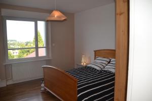 a bed in a room with a window at Gîte "Chez Paul" in Épinal