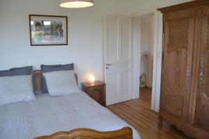 een slaapkamer met een bed en een houten dressoir bij Gîte "Chez Paul" in Épinal