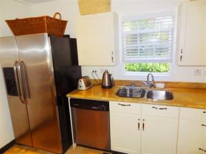 a kitchen with a stainless steel refrigerator and a sink at Brownes Condominium 2 in Bridgetown