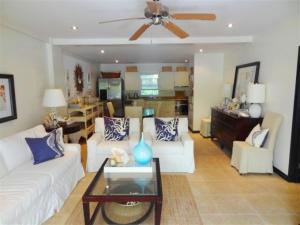 a living room with a white couch and a table at Brownes Condominium 2 in Bridgetown