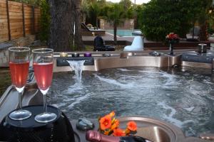 a pool with two glasses of wine and a fountain at Byblos Luxury Villa in Prinos
