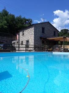 uma grande piscina em frente a um edifício de pedra em B&b Il Rustico em Sestri Levante