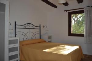 Schlafzimmer mit einem Bett und einem Fenster in der Unterkunft Mas de Bruquet in Llimiana