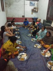 a group of people sitting around a table eating food at Hotel Jannat in Srinagar