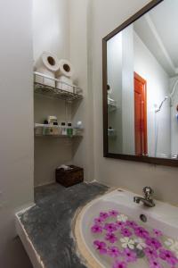 a bathroom with a sink with purple flowers on it at Sihariddh Guesthouse in Siem Reap