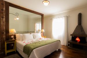 a bedroom with a bed and a lamp at Pousada Ouro de Minas in Tiradentes