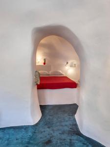 a bedroom with a bed in a white wall at Traditional Farmers Caves in Emporio
