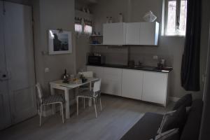 a kitchen with white cabinets and a table and chairs at Sea view Cornelia in Corniglia