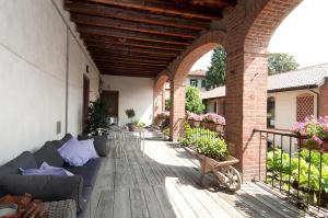 un patio extérieur avec un canapé sur une terrasse en bois dans l'établissement La Corte e l'Uva, à Olgiate Comasco