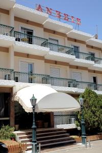 un bâtiment avec un parasol blanc devant lui dans l'établissement Hotel Anesi, à Athènes