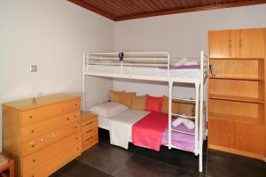 a bedroom with two bunk beds and a dresser at House Loana in Neos Marmaras