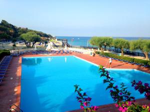 a large swimming pool with a view of the ocean at Villaggio Torre Ruffa in Capo Vaticano