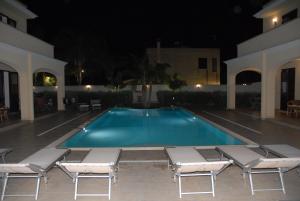 a swimming pool at night with lounge chairs and sidx sidx sidx sidx at Oasi Tortuga in Mazara del Vallo