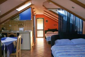 a kitchen and a living room with two beds and a table at Apartments Penovic in Kotor