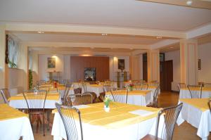 uma sala de jantar com mesas e cadeiras brancas em Casa Religiosa Di Ospitalità Nazareno em Spoleto