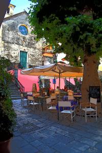un groupe de tables et de chaises sous un arbre dans l'établissement Sea view Cornelia, à Corniglia