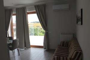 a living room with a couch and a large window at Boccy Brothers in Formia