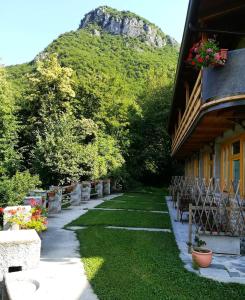 un jardin avec des chaises et un bâtiment avec une montagne en arrière-plan dans l'établissement Agriturismo La Selvaggia, à Mandello del Lario