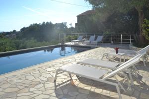 a swimming pool with two lounge chairs next to it at Apartments Padovan in Rab