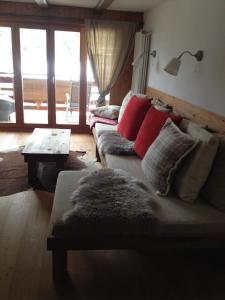 un soggiorno con divano e cuscini rossi di Les Boucanier a Verbier