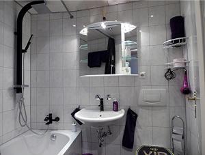 a bathroom with a sink and a mirror and a tub at Royal - Sky - Suite in Augsburg