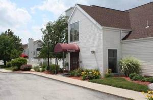 a white house with an awning next to a street at Suburban Studios in Fort Wayne
