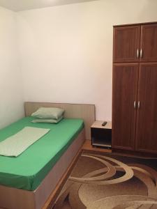 コンスタンツァにあるCasa Litoralのベッドルーム1室(ベッド1台付)、木製キャビネットが備わります。