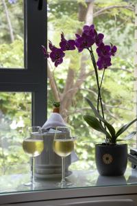 alféizar de la ventana con dos copas de vino y una flor en Hotel Vista al Sol, en Paterna