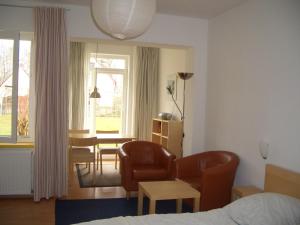 a hotel room with a bed and a table and chairs at Villa Nordstern in Göhren